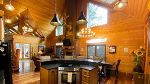 A spacious kitchen with wooden walls, a central island, and pendant lighting.