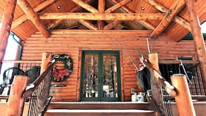 A wooden cabin with a porch, a green door, and a wreath.