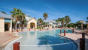 Ein Poolbereich mit mehreren Pools, Palmen und Liegestühlen.