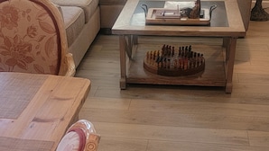 A living room with a wooden coffee table, a sofa, and a dining table with chairs.
