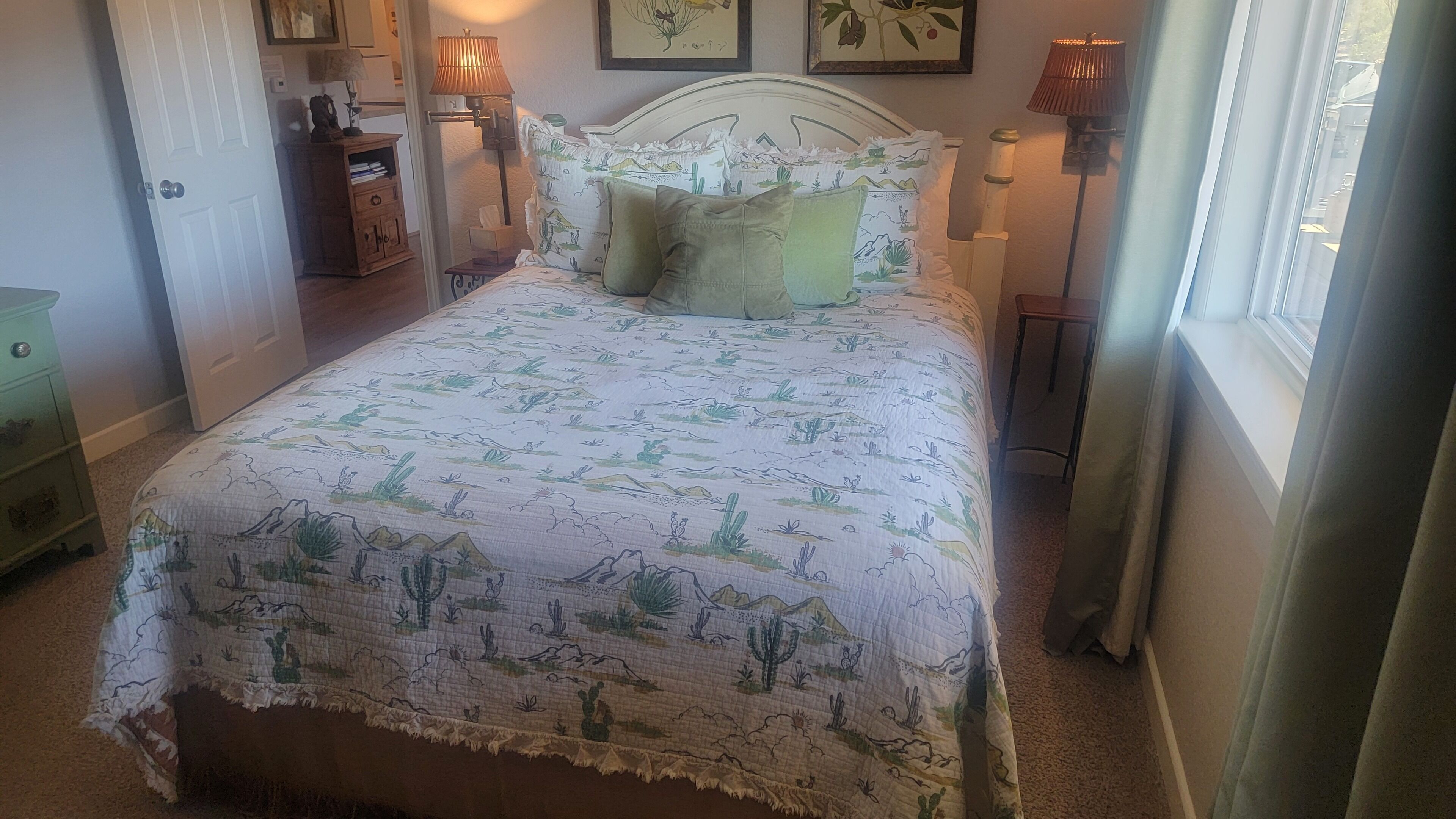 Une chambre à coucher comprenant un lit, une table de chevet, une commode et une fenêtre avec des rideaux.