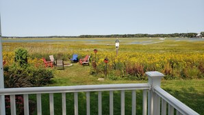 A grassy area with outdoor seating and a white fence. - Relaxing Hampton Beach Vacation Home (Hampton)