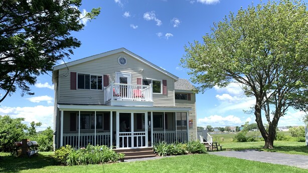 A two-story house with a covered porch and a balcony. - Relaxing Hampton Beach Vacation Home (Hampton)