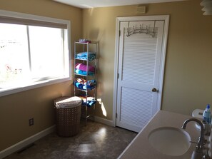 Een bad/douchecombinatie, een haardroger, handdoeken