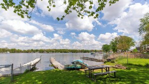 A lakeside park with a dock, picnic tables, and boats. - Vacation at Garver Lake ~ Private Beach For Your Enjoyment! (Edwardsburg)
