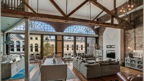 Amplia sala de estar con un sofá grande, una mesa de comedor y una zona de cocina.