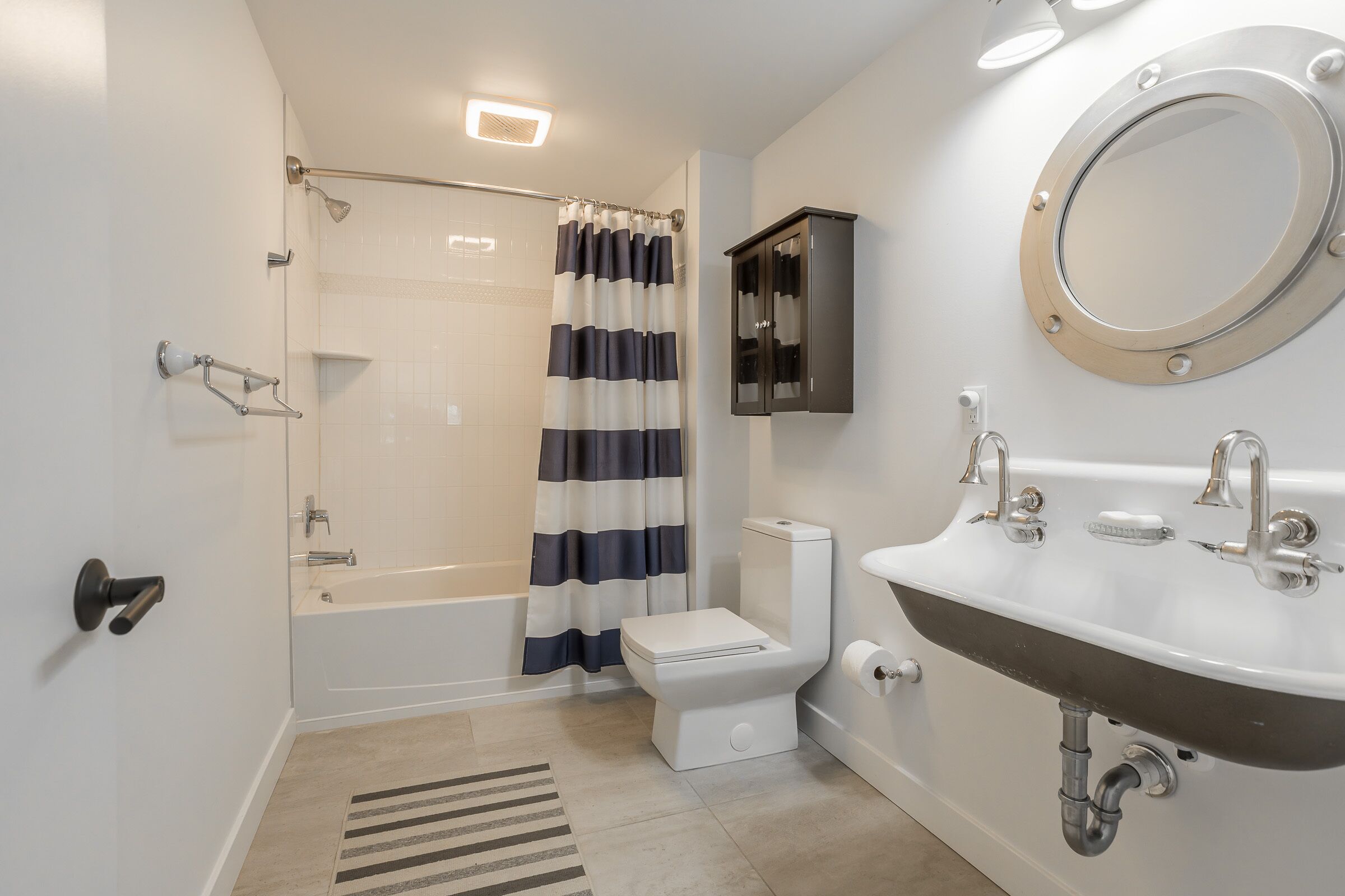 A modern bathroom with a bathtub, toilet, and sink.