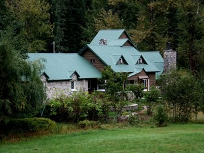 Una casa in pietra con tetto verde, immersa in una fitta foresta.