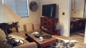 A living room with a sofa, a coffee table, a television, and a fireplace. -   Casita 3 blocks from downtown!  Very clean ! (Wickenburg)