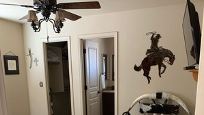 A bedroom with a bed, a ceiling fan, a horse-themed wall decoration, and a TV. -   Casita 3 blocks from downtown!  Very clean ! (Wickenburg)