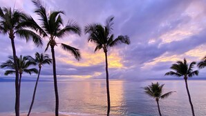 A beach with palm trees and a sunset over the ocean. - Direct Oceanfront Condo with Amazing Island Views!! (Lahaina)