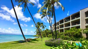 A hotel with a pool, palm trees, and a view of the ocean. - Direct Oceanfront Condo with Amazing Island Views!! (Lahaina)