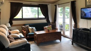 Una sala de estar acogedora con un sofá, una mesa de centro de madera y un televisor.