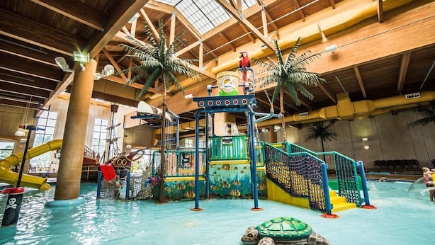 An indoor water park with a large pool, slides, and play structures. - Cozy Okoboji Vacation Home At Bridges Bay Resort - backs to pool! #118 (Arnolds Park)