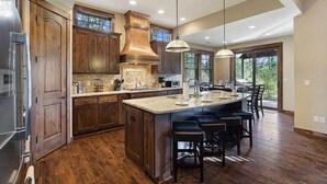 A spacious kitchen with wooden cabinets, a large island, and a built-in stove. - Central Location w/ Suncadia Pool Access (Cle Elum)