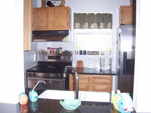 Fully equipped kitchen with a stove, sink, and refrigerator.