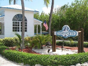 A building with a sign reading "Ocean Pointe" and an American flag.