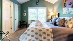 Une chambre à coucher avec un lit, une fenêtre, une porte et un ventilateur de plafond.