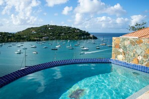 A swimming pool with a view of a marina and a hill with buildings. - Pink Conch - 2 Bedroom Luxury Villa, Great Cruz Bay, St. John - Backup generator (St. John)