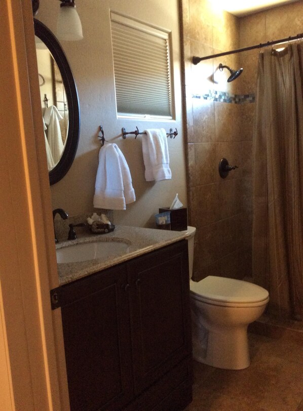 A bathroom with a sink, mirror, towel rack, and a shower area. - Casita only 3 blocks from downtown- Very clean! (Wickenburg)
