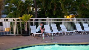Et hotel med poolområde, palmer og liggestole.