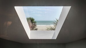 A skylight with a view of a beach and ocean.