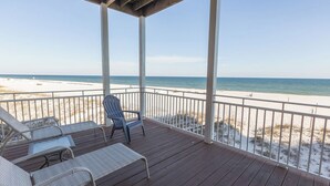A wooden deck with white railings overlooking a sandy beach and the ocean. - The Beach House - Panoramic Ocean Views & Beach Access Near Local Attractions (Orange Beach)