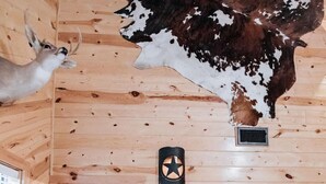 A wooden interior with a ceiling adorned with a cowhide, a star-shaped light fixture, and a sign listing amenities. - Casa Rio Hideaway @ Casa Rio Rentals- Pet Friendly with River access (Concan)
