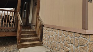 En trætrap fører op til en bygning med en stenvæg og et skilt, der viser "Nutter House".