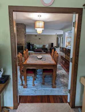 Un coin repas avec une table en bois, des chaises et un lustre.
