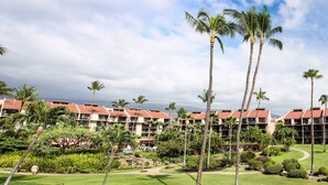 Ein Resort mit mehrstöckigen Gebäuden, Palmen und gepflegten Rasenflächen.