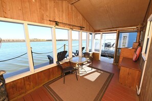 A wooden deck with a table and chairs, overlooking a body of water. - REELAXATION 'A comfortable Cabin on Apalachicola River.' New Water Filtration (Apalachicola)