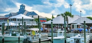 Enjoy waterfront dining and stunning views at this marina, where boats are moored and umbrellas provide shade.