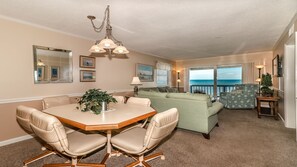 Cozy living area with a dining table for four, comfortable sofa, and ocean views.