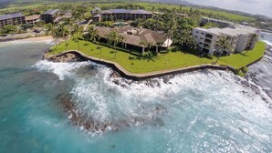 A coastal resort with multiple buildings, a beachfront, and a rocky shoreline.
