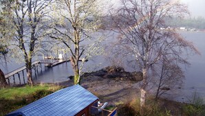 Eine Hütte mit blauem Dach, einem Steg und Blick auf einen See.