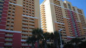A high-rise hotel with multiple balconies and a clear sky.