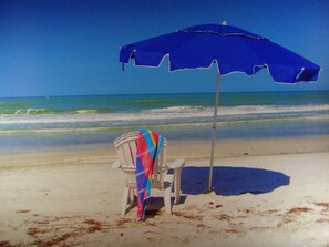 Ranta lähistöllä, aurinkotuoleja, rantapyyhkeitä