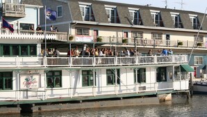 A multi-story boat with balconies and a flag, likely a hotel or restaurant.