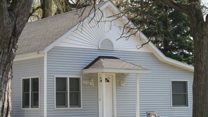 A single-story house with a gabled roof, a front porch, and a small front yard.