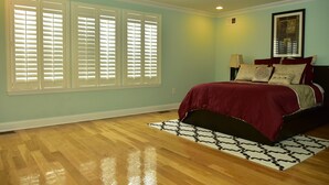 A bedroom with a bed, a patterned rug, and a window with blinds. - Beach Front,Ideal for family and couples,beautiful place for sunset lovers!!!!!! (Arverne)