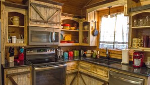 A rustic kitchen with wooden cabinets, a stove, and a dishwasher. - Beavers Bend State Park entrance 259A , Southern Hill Addition; Wood Knot Cabin (Broken Bow)