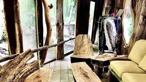 Un interior rústico con una mesa de centro de madera, un sofá y una percha para ropa.