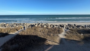 A beach with a rocky barrier and a clear view of the ocean. - Beach, Please: Best View of the Ocean with the Comforts of Home. 2bd/2ba (Carolina Beach)