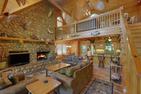 Living Room on Main Floor with TV and Wood Open Concept into Kitchen and Dining