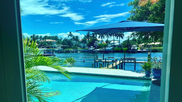 A clear view of a swimming pool with a dock and boats in the background.