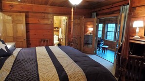 Una habitación de cabaña de madera con una cama, un escritorio y una silla.
