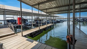 A marina with docked boats, covered walkways, and a calm water body.