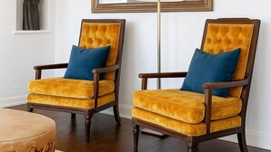 Two armchairs with yellow velvet upholstery and blue cushions, a tall floor lamp, and a large mirror on the wall. - Stay close to concerts, sports and culture in our artistic historic monarch home (Phoenix)