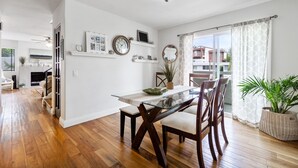 A spacious dining area with a glass table and wooden chairs, a fireplace, and a view of the outside. - Beautiful Ocean View (San Clemente)